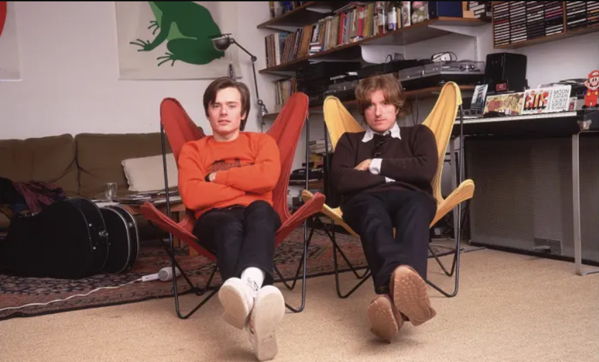 Men sitting in chairs in a room
Description automatically generated