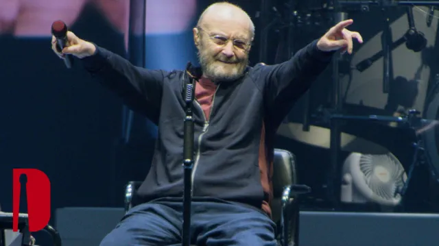 A person sitting in a chair with his arms raised
Description automatically generated