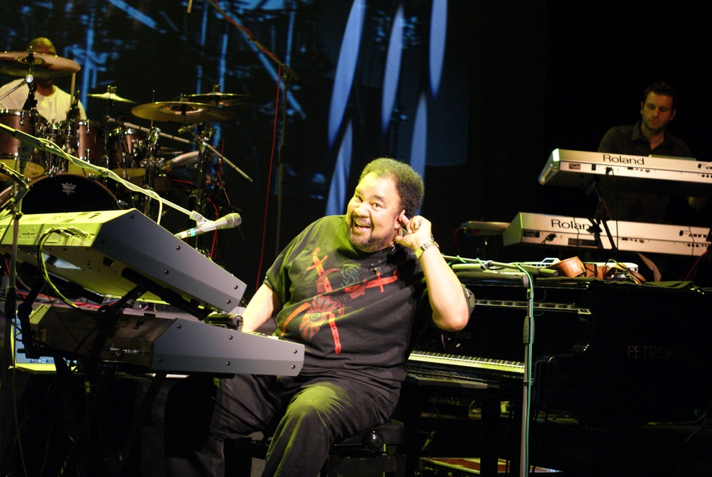 A person sitting on a chair with a keyboard and microphones
Description automatically generated