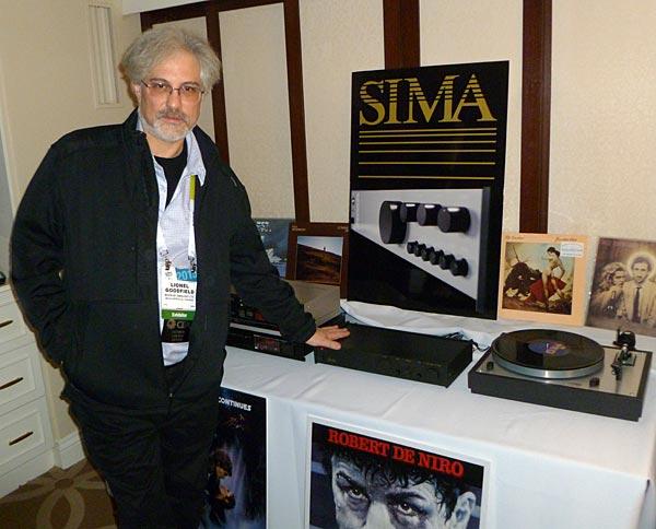 A person standing next to a table with a record player

Description automatically generated