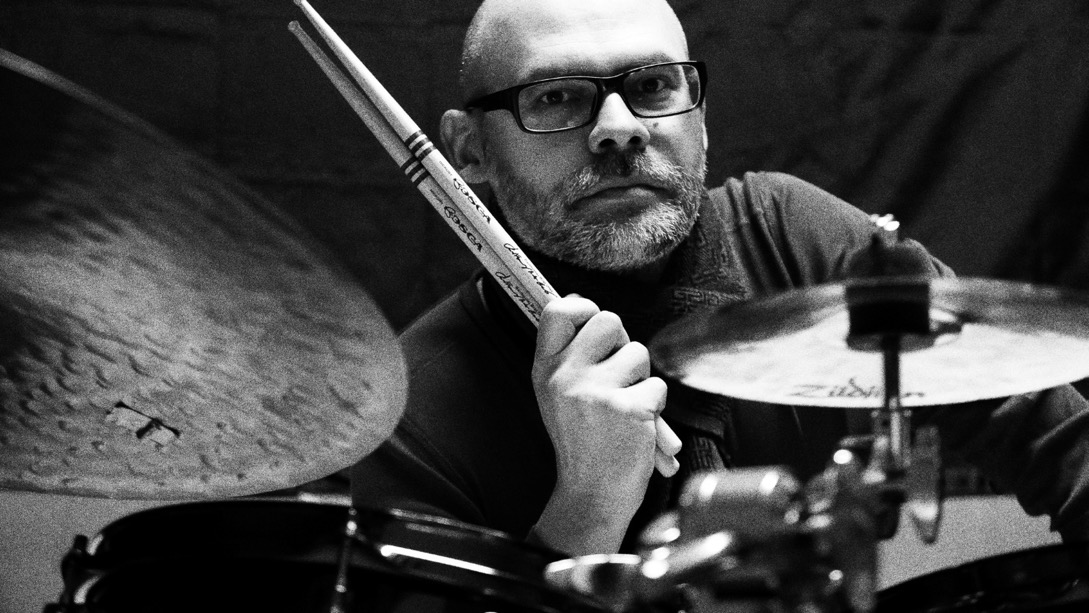 A person holding a drum set
Description automatically generated