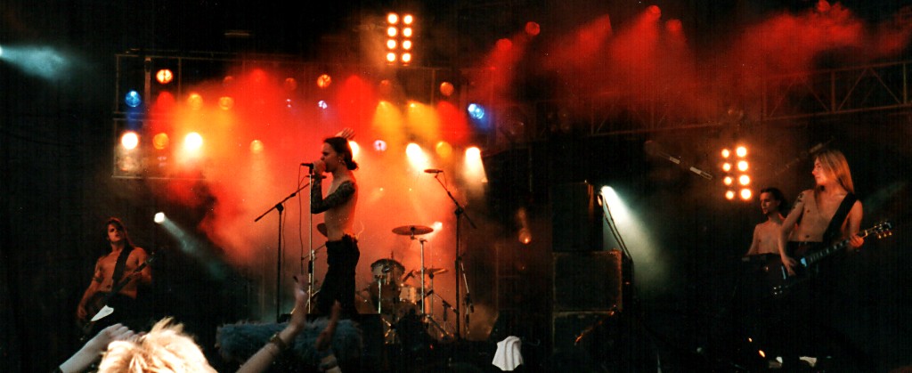 A person on stage with microphones and lights
Description automatically generated